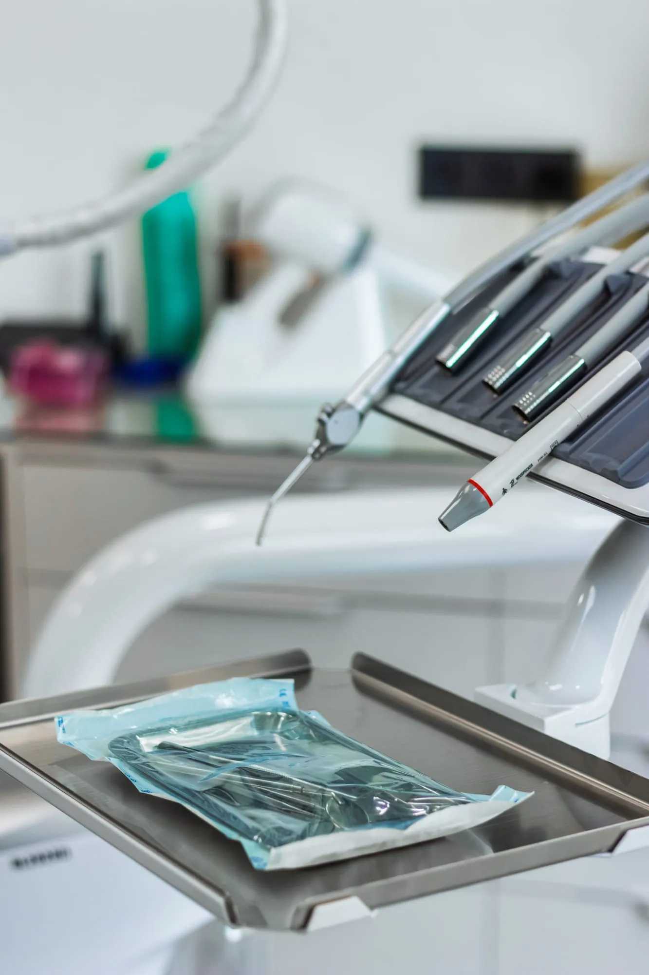 Instruments dentaires dans leur sachet de stérilisation scellé, à côté des pièces à main